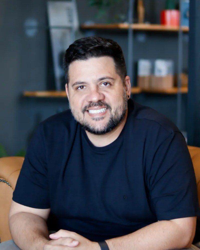 Marco Medeiro, sócio e arquiteto da Contemporano, sentado no sofá de couro do escritório